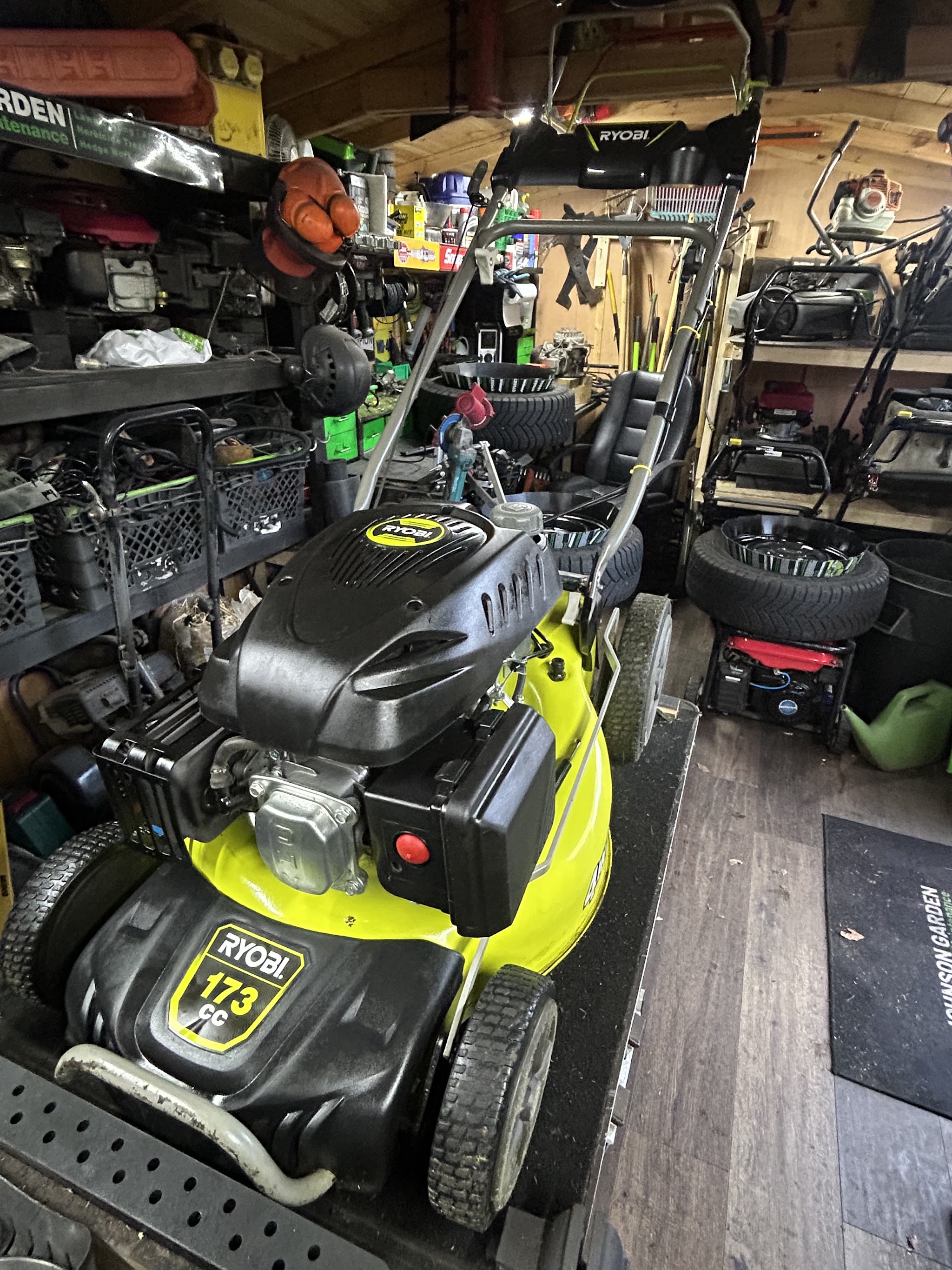 Inside our van: mowers and tools racked and ready, with the Johnson Garden mat on the floor